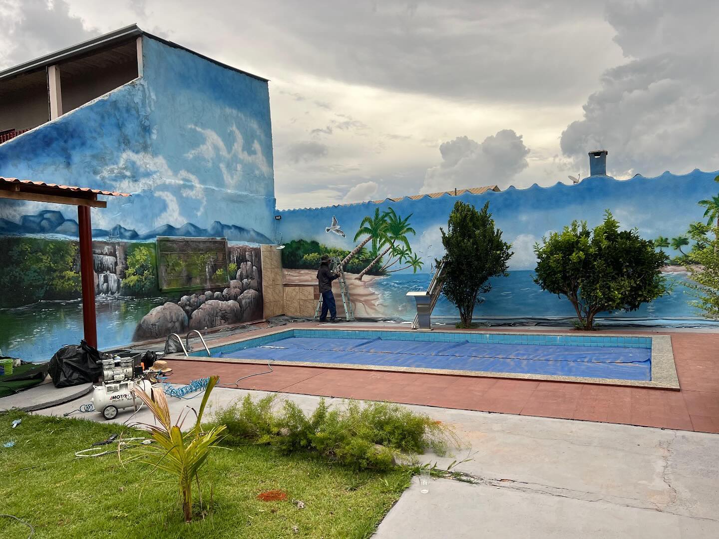 Piscina do LB Espaço para Eventos com muro decorado com pintura de paisagem