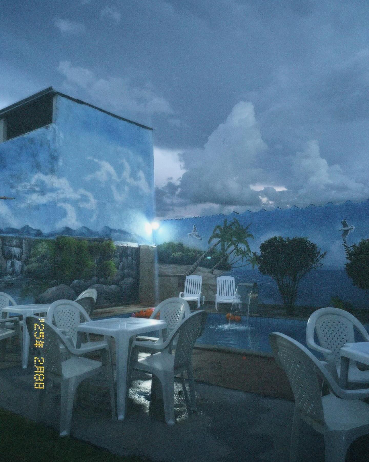 Área da piscina do LB Espaço para Eventos ao entardecer, com mesas e cadeiras